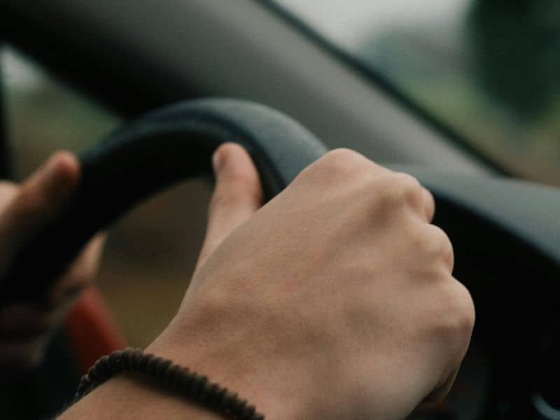 Close-up of hands on steering wheel during Flexible Car Rental drive